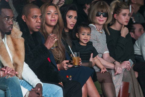 Kim Kardashian holds her daughter, North, while sitting next to Sean Combs (L), Jay-Z (2nd L), Beyonce (3rd L) and Anna Wintour (3rd R) as they watch a presentation of Kanye West's Fall/Winter 2015 partnership with Adidas at New York Fashion Wee